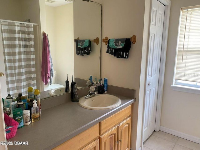 bathroom featuring tile patterned flooring, a closet, vanity, and curtained shower