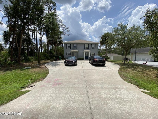 colonial house with a front lawn and concrete driveway
