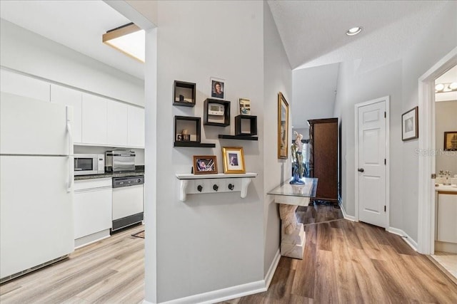 69 Rivers Edge Ln Unit 69, Palm Coast, FL 32137 - hallway with light wood finished floors, baseboards, lofted ceiling, and recessed lighting