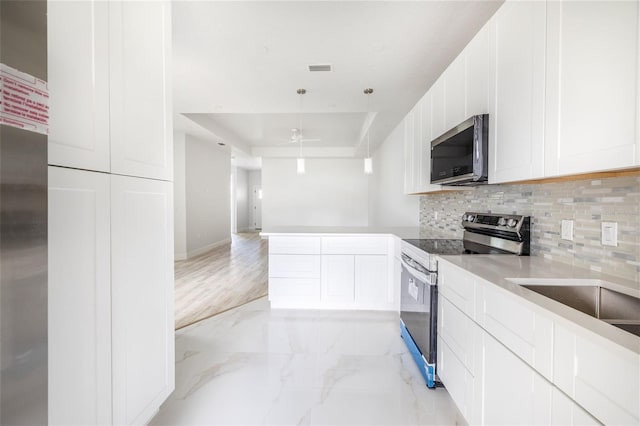 8 Bunker View Pl, Palm Coast, FL 32137 - kitchen featuring stainless steel appliances, decorative backsplash, light marble finish floors, and white cabinetry