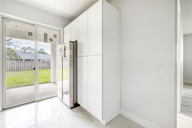 8 Bunker View Pl, Palm Coast, FL 32137 - kitchen featuring freestanding refrigerator, white cabinets, and baseboards