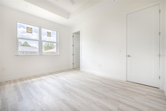8 Bunker View Pl, Palm Coast, FL 32137 - unfurnished bedroom featuring light wood-style flooring, baseboards, and a tray ceiling