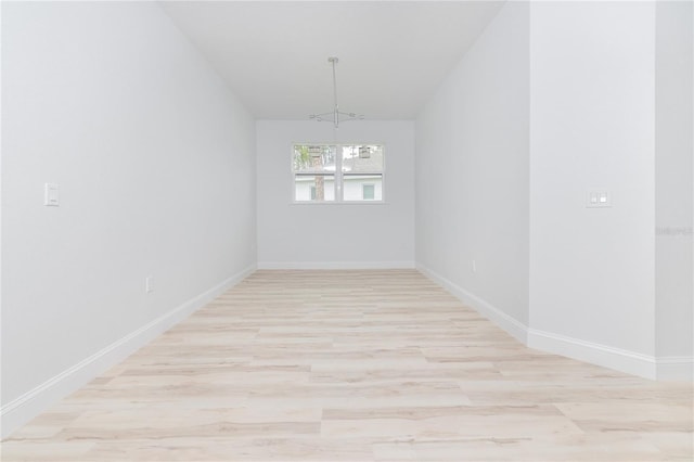 8 Bunker View Pl, Palm Coast, FL 32137 - unfurnished room featuring a chandelier, light wood finished floors, vaulted ceiling, and baseboards