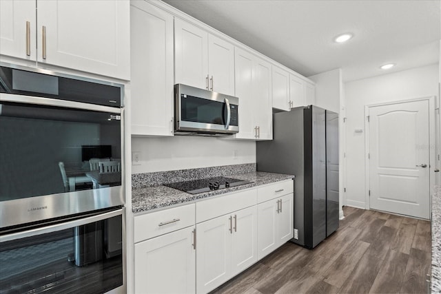 3828 S Atlantic Ave, Daytona Beach, FL 32118 - kitchen with appliances with stainless steel finishes, light stone counters, white cabinets, dark wood-style flooring, and recessed lighting