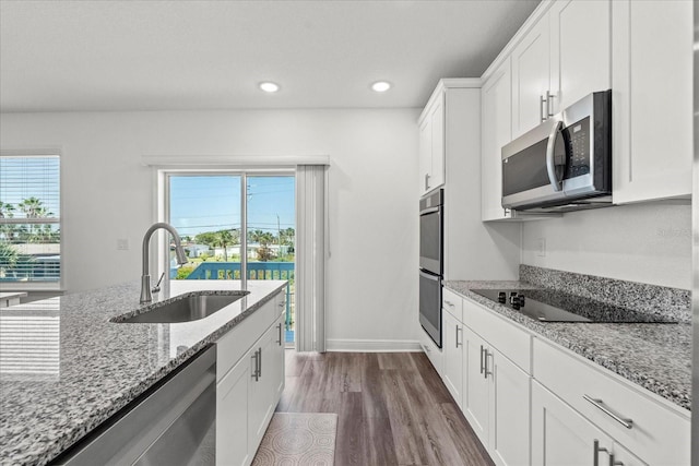 3828 S Atlantic Ave, Daytona Beach, FL 32118 - kitchen featuring stainless steel appliances, white cabinetry, dark wood-style flooring, recessed lighting, and light stone countertops
