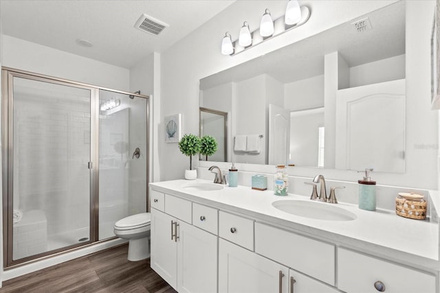 3828 S Atlantic Ave, Daytona Beach, FL 32118 - bathroom with double vanity, a shower stall, and wood finished floors