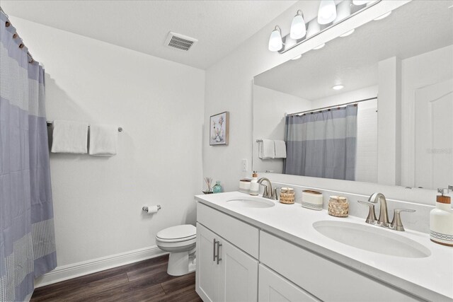 3828 S Atlantic Ave, Daytona Beach, FL 32118 - bathroom featuring wood finished floors, double vanity, and a shower with shower curtain