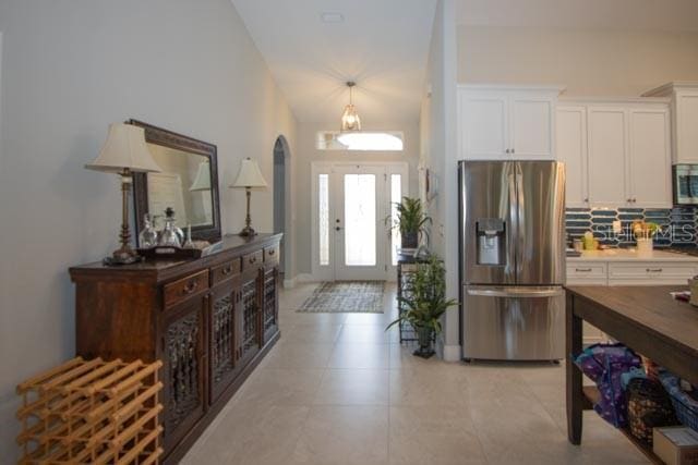 37 Lagoon Way, Palm Coast, FL 32137 - foyer with arched walkways, light tile patterned floors, and high vaulted ceiling
