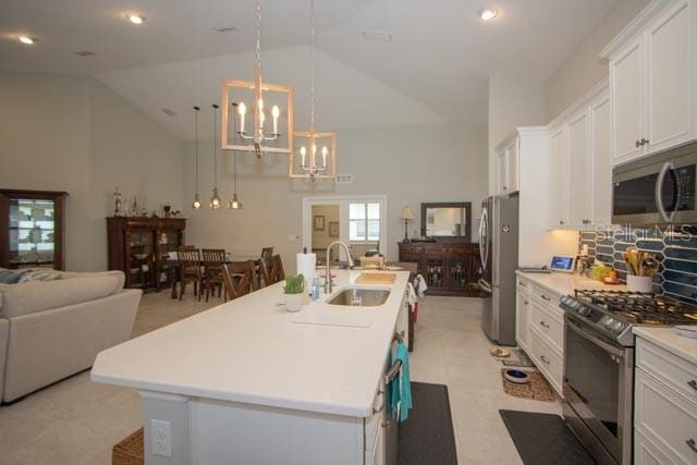 37 Lagoon Way, Palm Coast, FL 32137 - kitchen with appliances with stainless steel finishes, a sink, open floor plan, a chandelier, and high vaulted ceiling