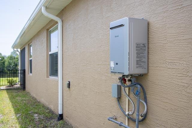 37 Lagoon Way, Palm Coast, FL 32137 - exterior view of stucco siding and tankless water heater