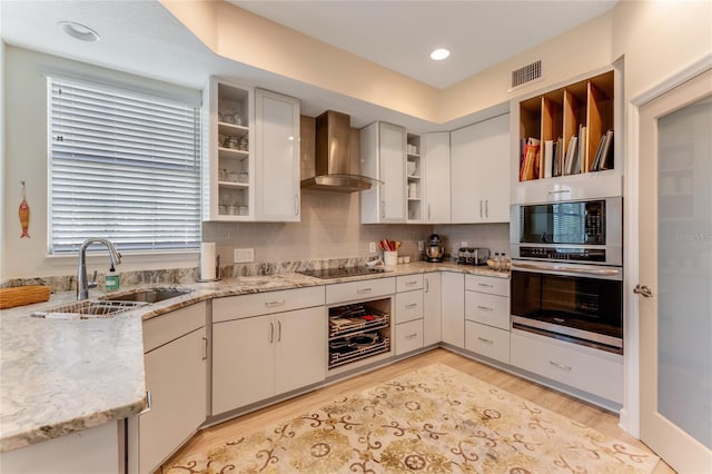 200 Riverfront Dr Unit B204, Palm Coast, FL 32137 - kitchen with oven, wall chimney exhaust hood, a sink, open shelves, and black electric cooktop
