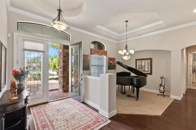 716 Woodbridge Ct, Ormond Beach, FL 32174 - foyer featuring a tray ceiling, dark wood finished floors, arched walkways, a chandelier, and baseboards