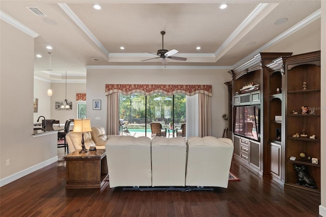 716 Woodbridge Ct, Ormond Beach, FL 32174 - living room featuring ceiling fan, a tray ceiling, dark wood-style flooring, ornamental molding, and baseboards
