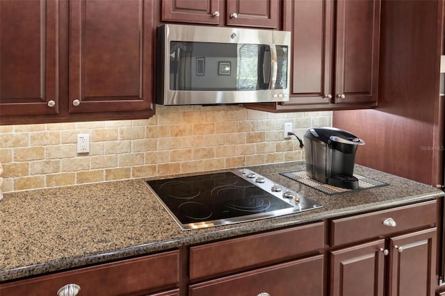 716 Woodbridge Ct, Ormond Beach, FL 32174 - kitchen with stainless steel microwave, electric stovetop, backsplash, and dark stone counters