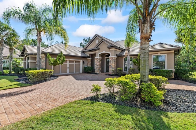 716 Woodbridge Ct, Ormond Beach, FL 32174 - view of front facade with stucco siding, stone siding, a tile roof, an attached garage, and driveway