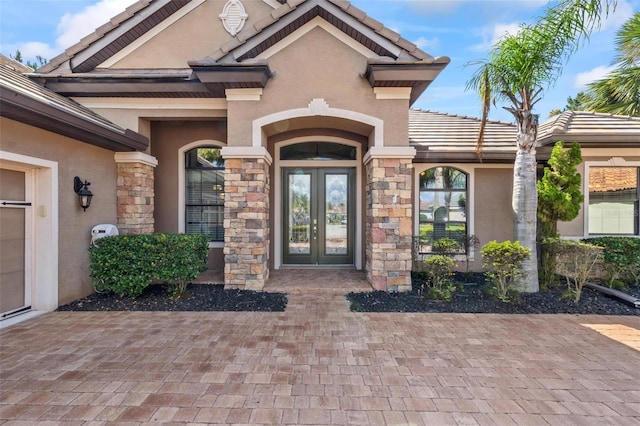 716 Woodbridge Ct, Ormond Beach, FL 32174 - property entrance featuring french doors, stucco siding, stone siding, and a tiled roof