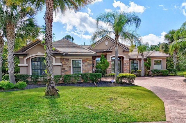 716 Woodbridge Ct, Ormond Beach, FL 32174 - view of front of home featuring stucco siding, a front lawn, decorative driveway, and a tile roof