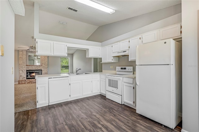 2212 Cortez Ct, Middleburg, FL 32068 - kitchen with white appliances, under cabinet range hood, a sink, white cabinetry, and vaulted ceiling