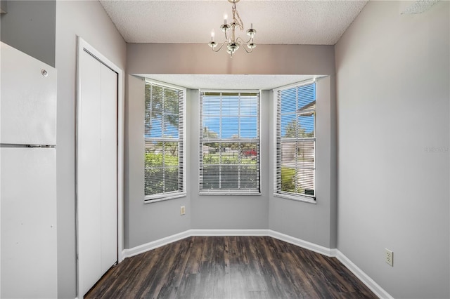 2212 Cortez Ct, Middleburg, FL 32068 - unfurnished dining area featuring wood finished floors, healthy amount of natural light, a chandelier, baseboards, and a textured ceiling