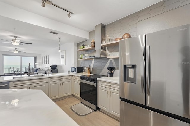 80 Surfview Dr Unit 511, Palm Coast, FL 32137 - kitchen featuring stainless steel appliances, wall chimney range hood, light countertops, a sink, and light wood-type flooring