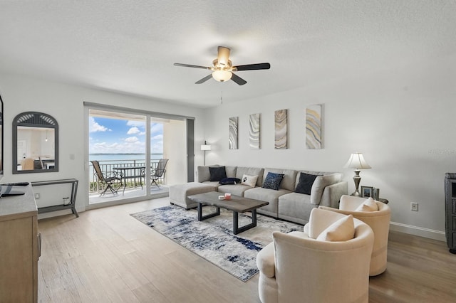 80 Surfview Dr Unit 511, Palm Coast, FL 32137 - living room with ceiling fan, wood finished floors, baseboards, a water view, and a textured ceiling