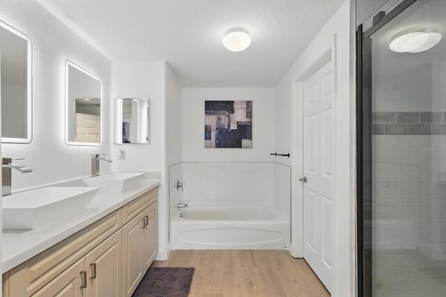 80 Surfview Dr Unit 511, Palm Coast, FL 32137 - full bath featuring wood finished floors, a garden tub, double vanity, and a textured ceiling