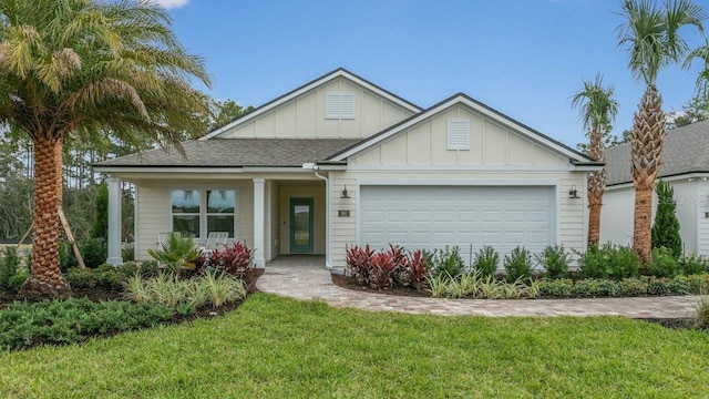151 Greenwood Dr, Palm Coast, FL 32137 - view of front of property featuring board and batten siding, a garage, a front lawn, and covered porch