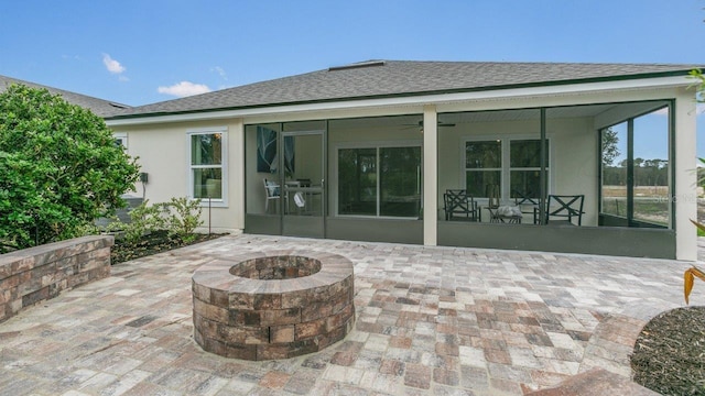 151 Greenwood Dr, Palm Coast, FL 32137 - back of house featuring a sunroom, a patio, a fire pit, and stucco siding
