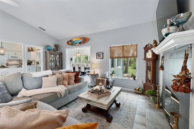 135 Lambert Ave, Flagler Beach, FL 32136 - living room featuring vaulted ceiling, light wood-style floors, and baseboards