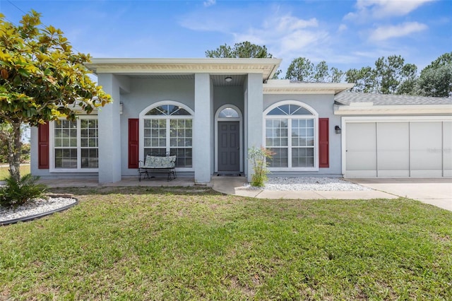 view of front facade featuring an attached garage, a front lawn, concrete driveway, and stucco siding