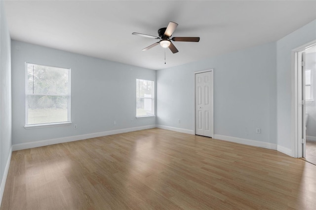 unfurnished room featuring a ceiling fan, light wood-style flooring, and baseboards