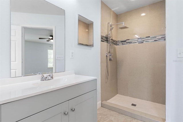 bathroom featuring tiled shower, a ceiling fan, and vanity