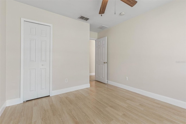 unfurnished bedroom with light wood-type flooring, baseboards, a ceiling fan, and a closet