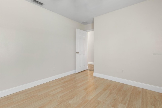spare room featuring light wood finished floors and baseboards