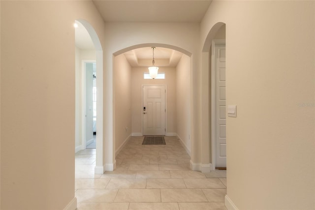 2840 Monaghan Dr, Ormond Beach, FL 32174 - entryway featuring a tray ceiling, light tile patterned floors, and arched walkways