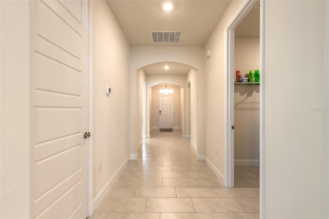 2840 Monaghan Dr, Ormond Beach, FL 32174 - corridor with arched walkways, light tile patterned floors, and baseboards