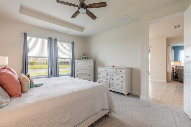 2840 Monaghan Dr, Ormond Beach, FL 32174 - bedroom with light colored carpet, baseboards, ceiling fan, a tray ceiling, and light tile patterned floors