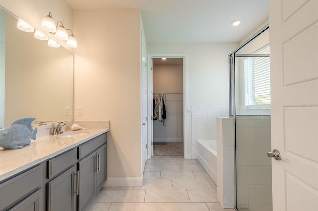 2840 Monaghan Dr, Ormond Beach, FL 32174 - bathroom featuring tile patterned flooring, vanity, a garden tub, baseboards, and an enclosed shower