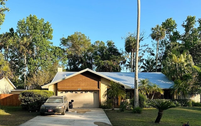 20 Blakeshire Pl, Palm Coast, FL 32137 - ranch-style house with an attached garage, concrete driveway, metal roof, and a chimney