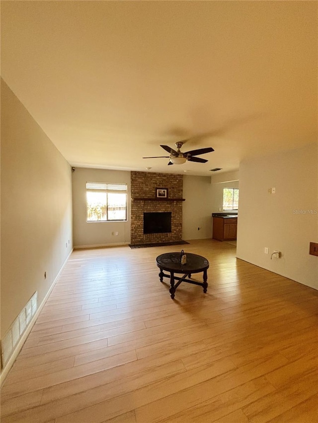 20 Blakeshire Pl, Palm Coast, FL 32137 - unfurnished living room with light wood-style flooring, a ceiling fan, and a brick fireplace