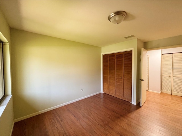 20 Blakeshire Pl, Palm Coast, FL 32137 - unfurnished bedroom featuring wood finished floors, baseboards, and a closet