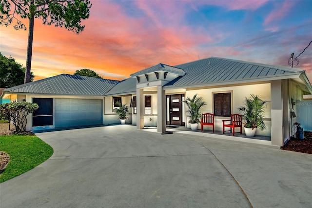 54 Fordham Ln, Palm Coast, FL 32137 - view of front facade with metal roof, a garage, concrete driveway, a standing seam roof, and stucco siding