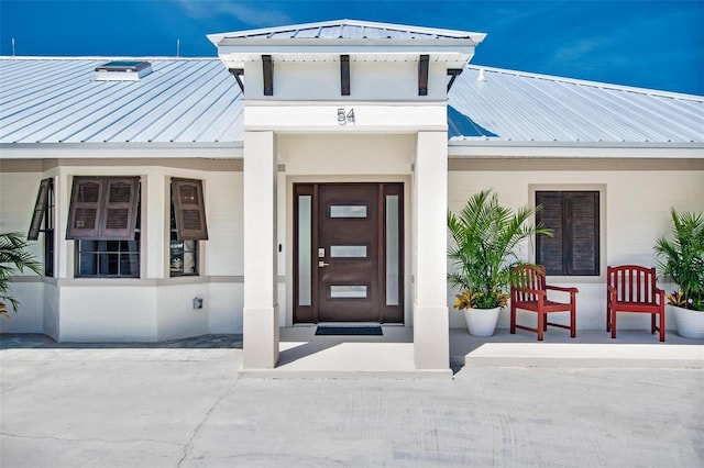 54 Fordham Ln, Palm Coast, FL 32137 - doorway to property with metal roof, covered porch, and a standing seam roof