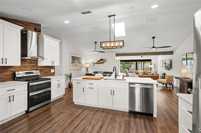 54 Fordham Ln, Palm Coast, FL 32137 - kitchen with wall chimney exhaust hood, stainless steel appliances, ceiling fan, a sink, and open floor plan