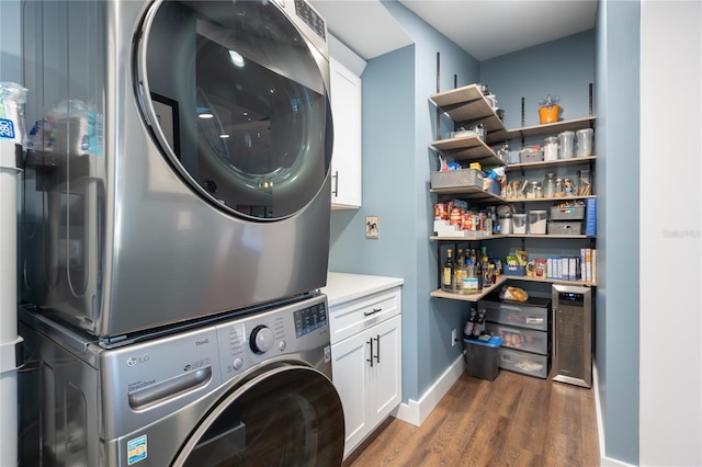 54 Fordham Ln, Palm Coast, FL 32137 - washroom featuring stacked washer and clothes dryer, dark wood-type flooring, beverage cooler, baseboards, and cabinet space