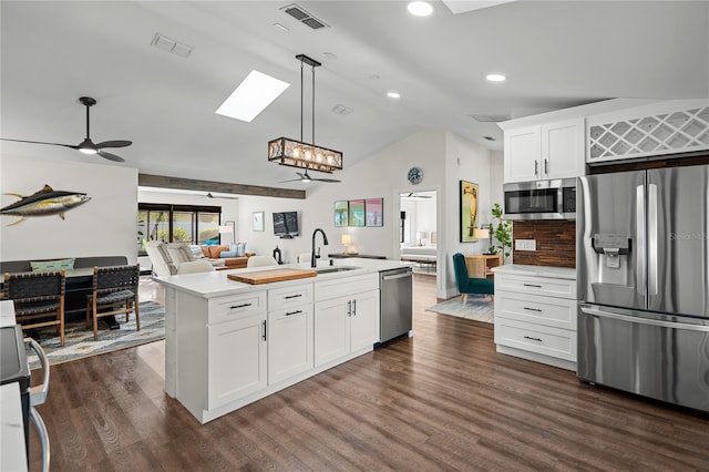 54 Fordham Ln, Palm Coast, FL 32137 - kitchen featuring appliances with stainless steel finishes, a sink, open floor plan, vaulted ceiling, and light countertops