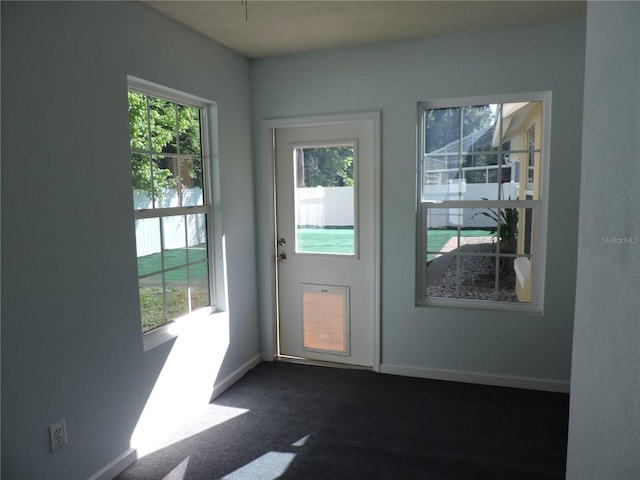 543 Sandy Oaks Blvd, Ormond Beach, FL 32174 - doorway featuring baseboards and dark colored carpet