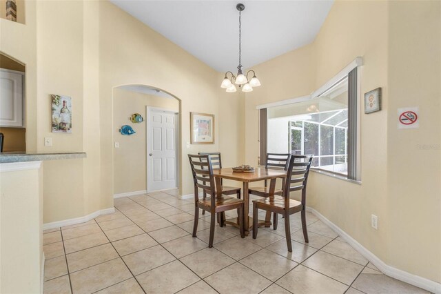 11 White Oak Ln, Palm Coast, FL 32164 - dining room featuring light tile patterned flooring, arched walkways, a chandelier, baseboards, and high vaulted ceiling