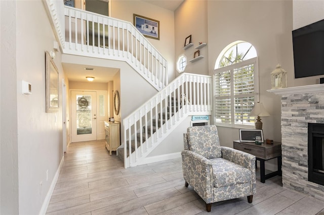 7 Bristol Dr, Palm Coast, FL 32137 - entryway with a towering ceiling, stairs, wood finished floors, a fireplace, and baseboards
