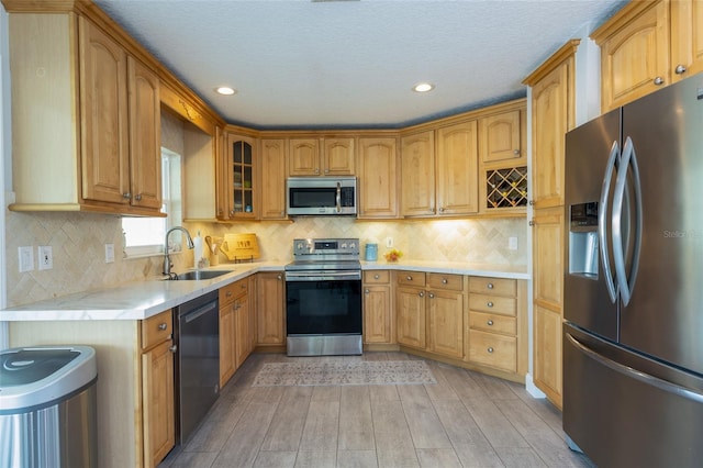 7 Bristol Dr, Palm Coast, FL 32137 - kitchen with stainless steel appliances, a sink, light wood-style flooring, recessed lighting, and glass insert cabinets
